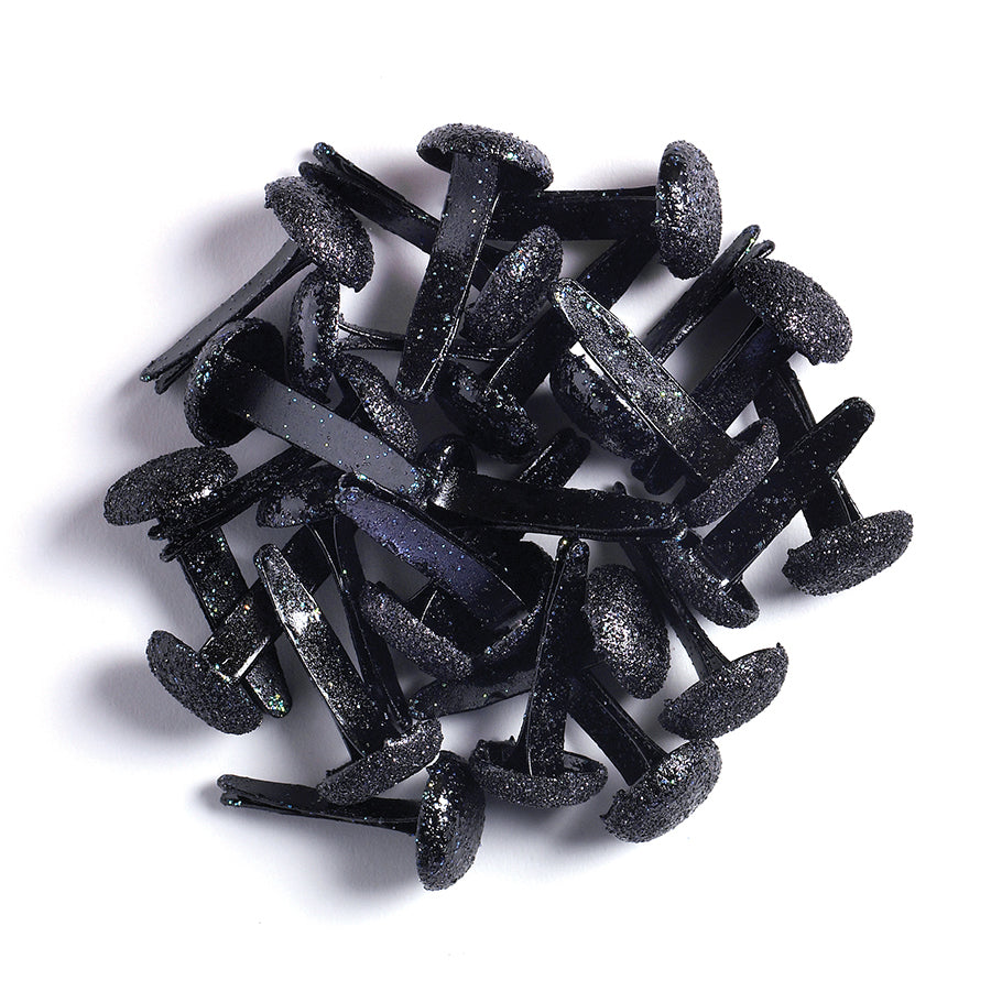 Black sugar-coated metal brads on a white background