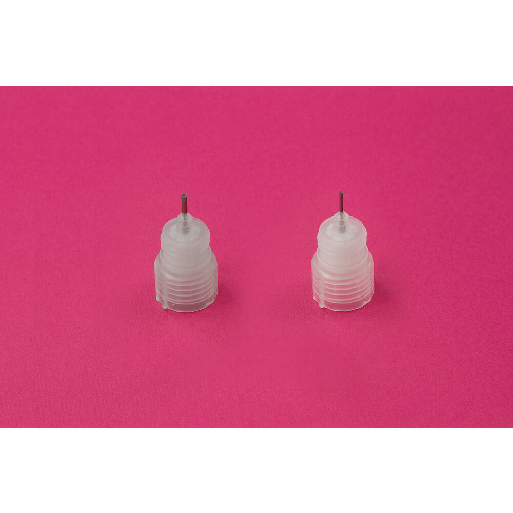 Two clear plastic precision nozzles on a pink background