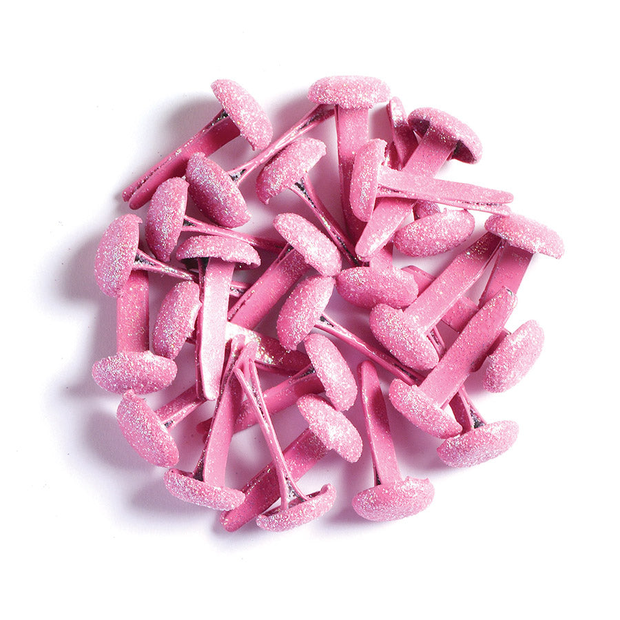 Pink glittery metal brads on a white background