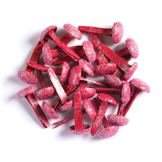 Red glittery metal brads on a white background