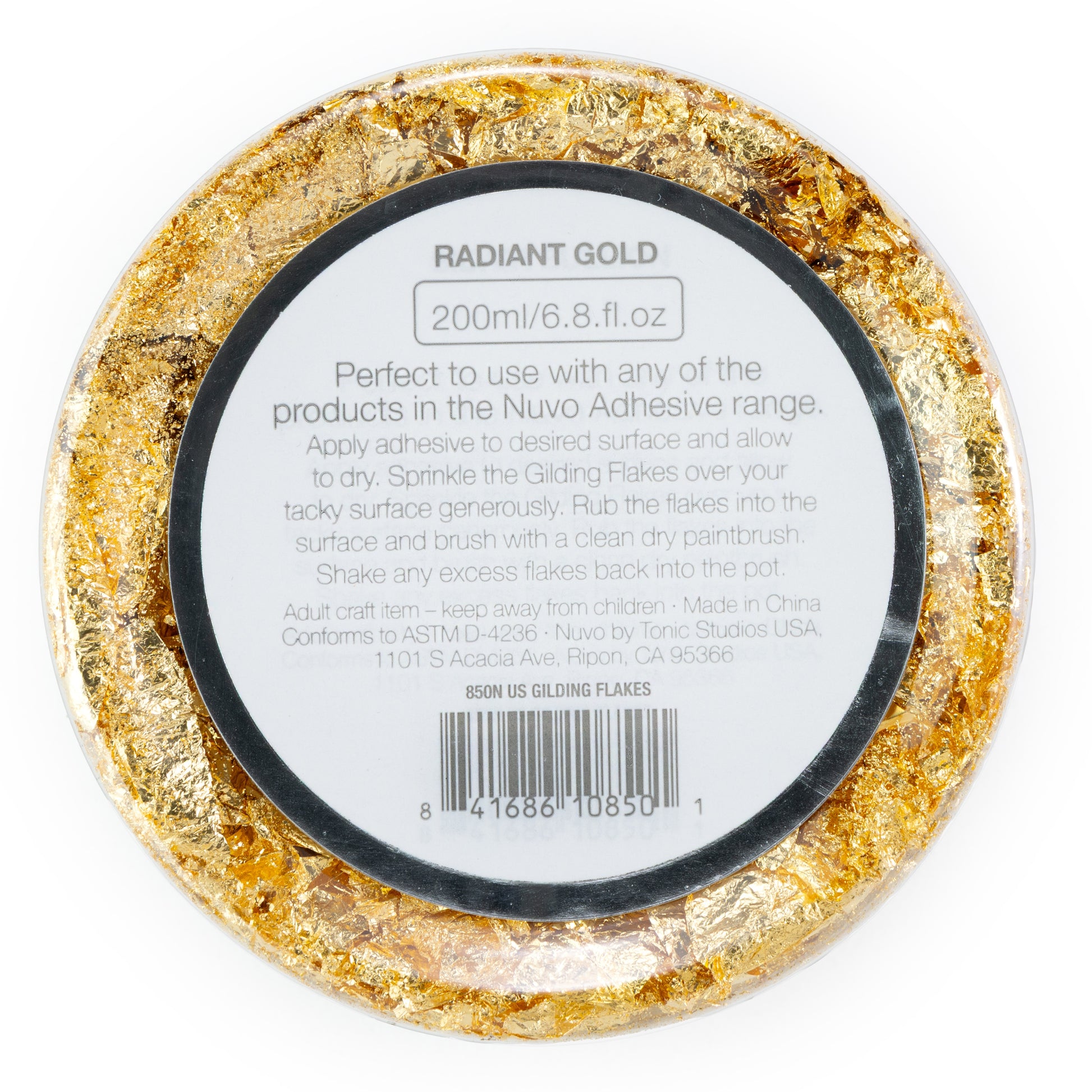 Gold gilding flakes in a round container with a label on a white background
