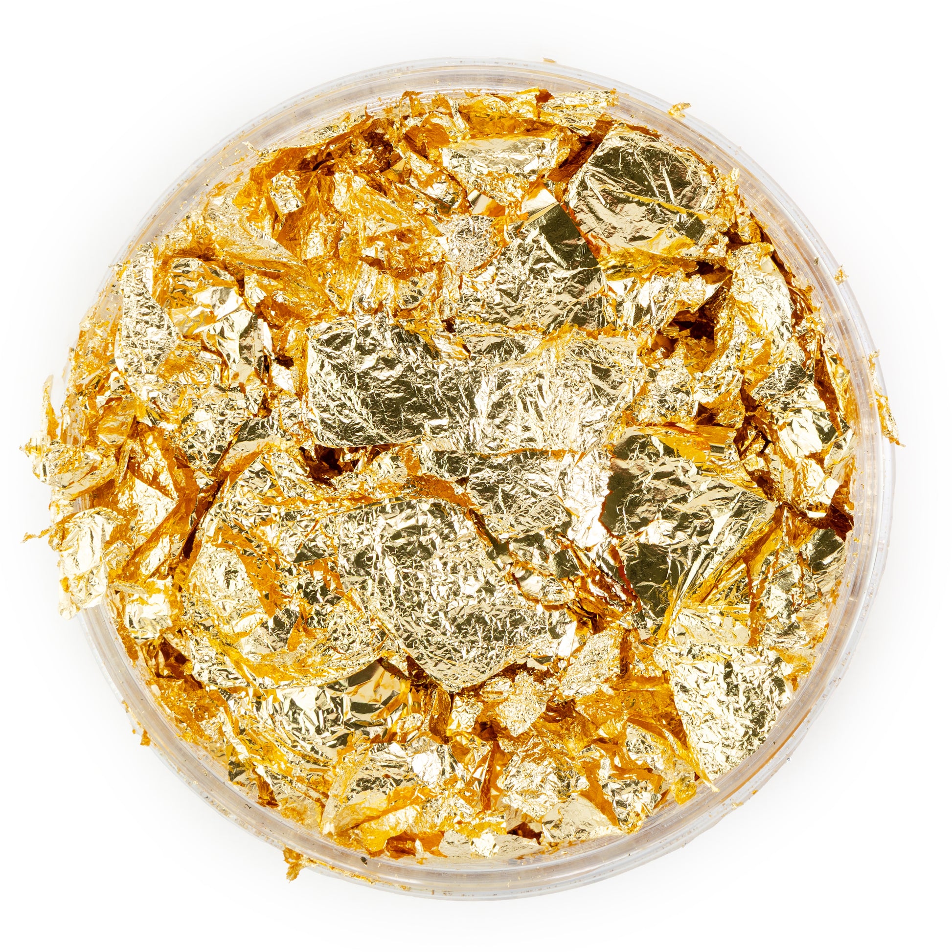 Gold leaf pieces in a container on a white background
