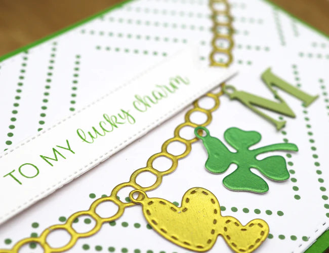 Card with gold chain, green clover charm, and text 'To my lucky charm' on a white background.
