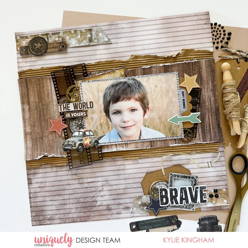 A scrapbook layout featuring a central photo of a young boy, styled with vintage-inspired elements including distressed paper, a small car, stars, film strips, and decorative text. The layout is presented on a white background with branding for 'uniquely DESIGN TEAM' and 'KYLIE KINGHAM' at the bottom.
