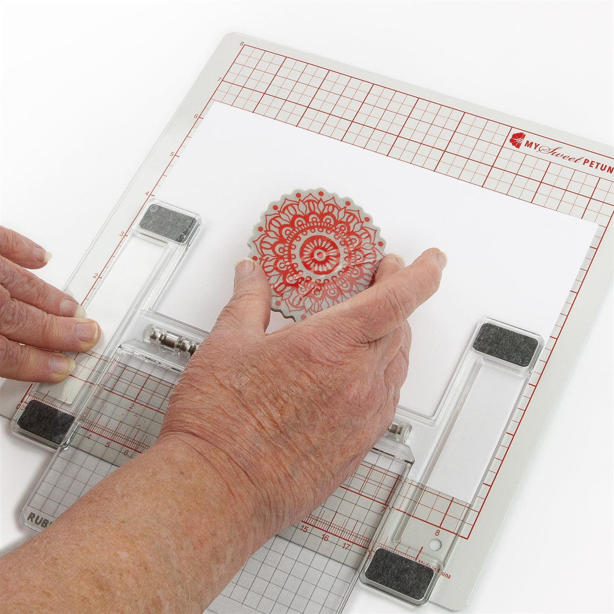 Person using a stamp on the grid surface of a MISTI Lite.