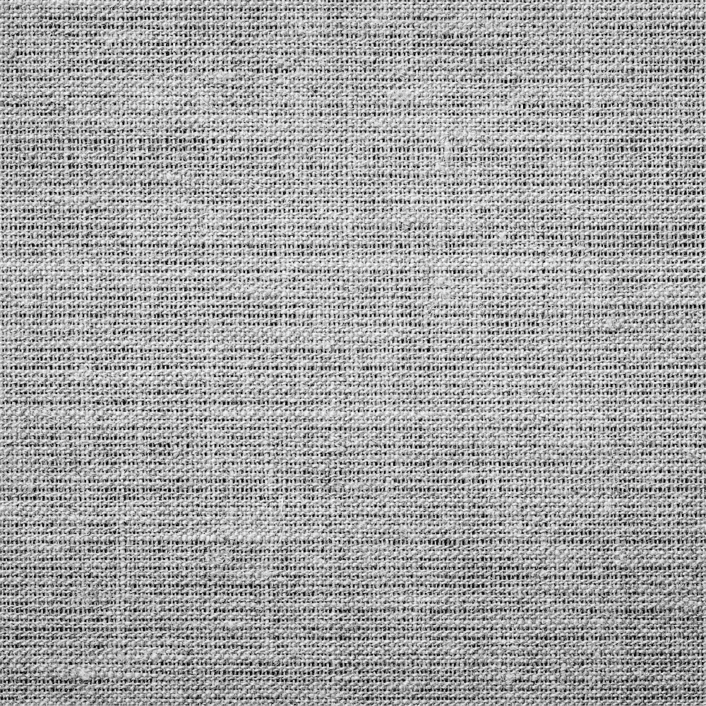 A close-up texture shot of a woven fabric, showing a detailed linen-like pattern in light gray and white.