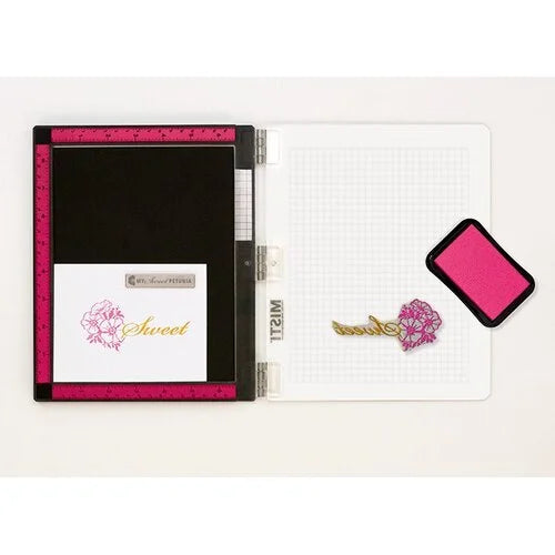 An open MISTI stamp tool with a stamped image on the platform